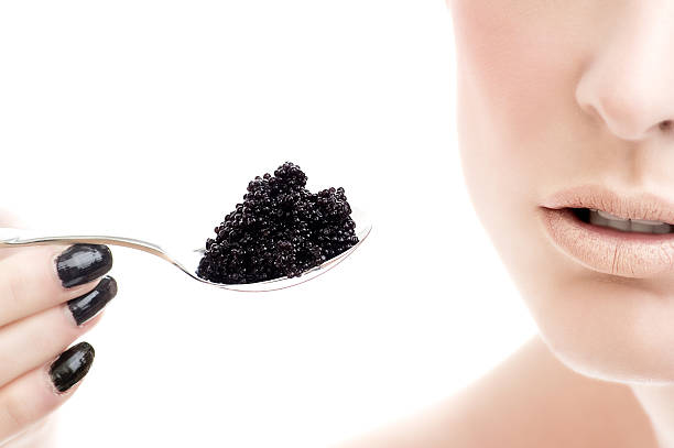 Woman Holding Spoonful of Caviar stock photo