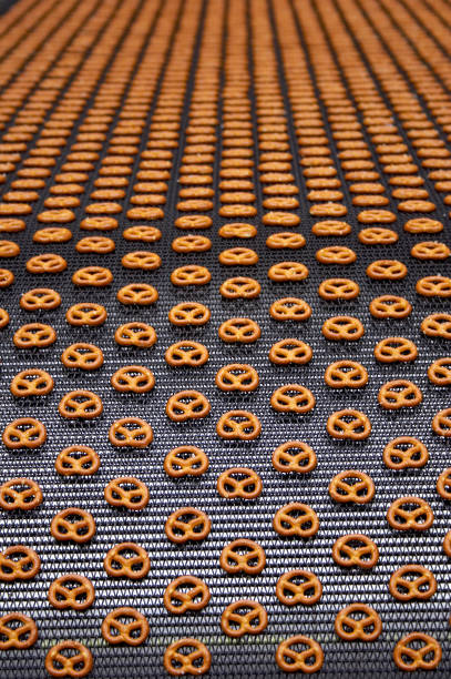 pretzels na correia transportadora em fábrica - pretzel snack salty food imagens e fotografias de stock