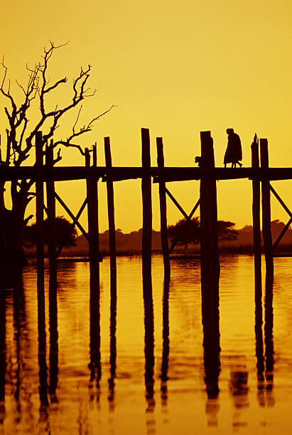 A Burmese girl walks on a bridge at a major tourist attraction in Mandalay Province, Myanmar.