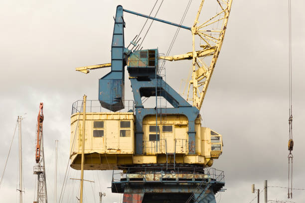 istock Old heavy harbor jib crane in seaport. 1081492522
