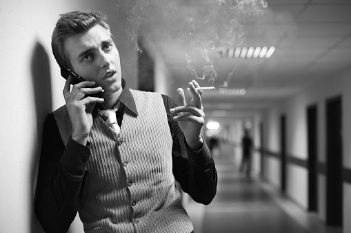young  business man, smoking, concerned, b/w, a little grain