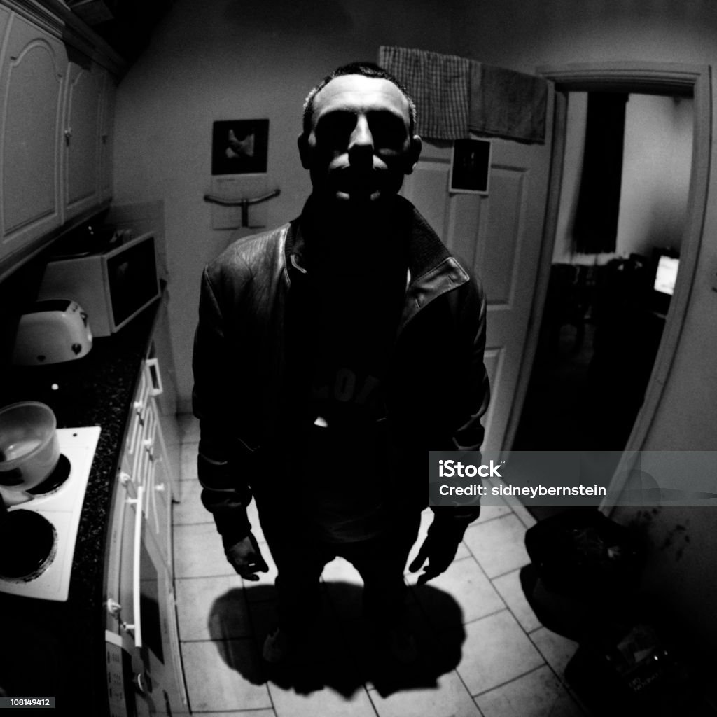 Man Standing in Shadows of Kitchen Lighting, Low Key  Crime Stock Photo