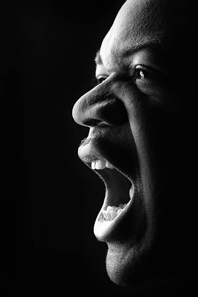 Portrait of Young Man Yelling, Low Key Black and White stock photo