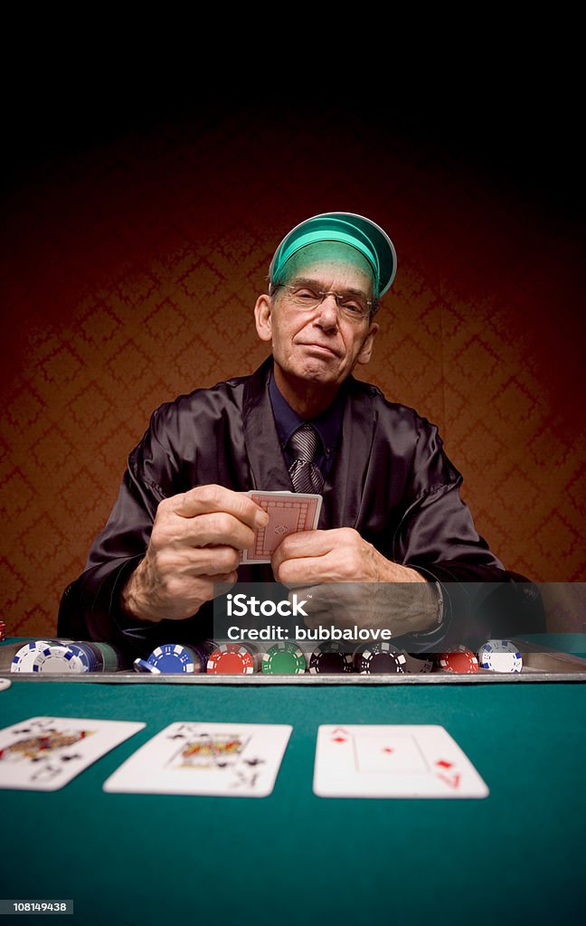 Senior Man ラウンジでカードポーカーのテーブルと遊ぶ - スモーキングジャケットのロイヤリティフリーストックフォト