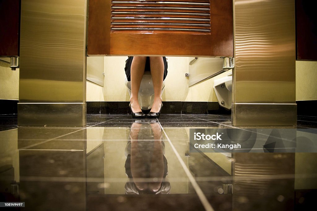 Женщина сидит на туалет - Стоковые фото Общественный туалет роялти-фри