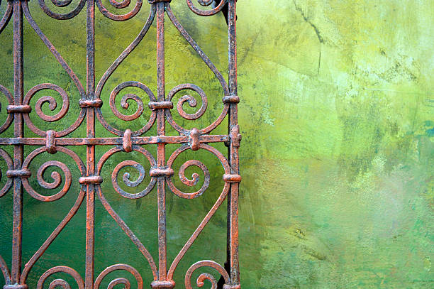 Wrought iron fence against green wall stock photo