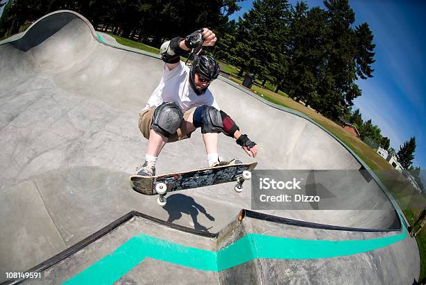 Foto de Masculino Skatista No Skate Park Em Dia Ensolarado e mais fotos de stock de Andar de Skate - Andar de Skate, Parque de Skate, Capacete - Equipamento