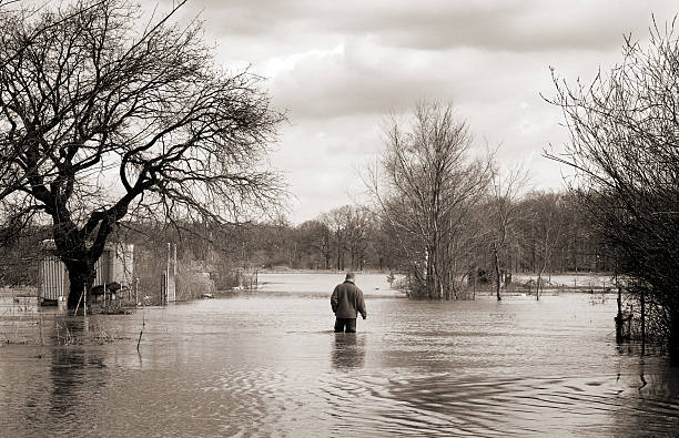 istock flood man walking alone through the high water 108149623