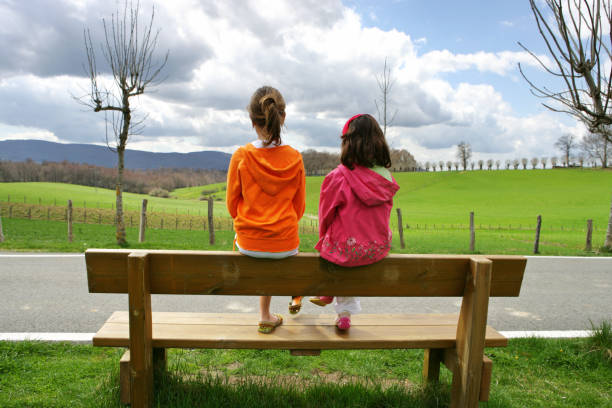 istock Two Little Girls Sitting on Bench and Looking Out 108149644