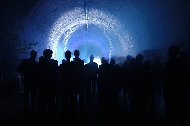 silhouettes of people in the dark tunnel