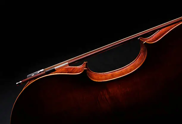 Photo of Cello silhouette with bow on black background