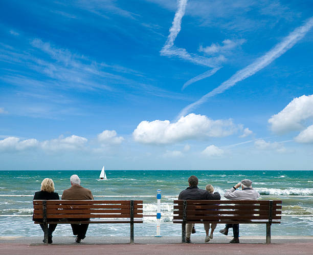 istock People Sitting on Benches Near Ocean Coast During Sunny Day 108149930