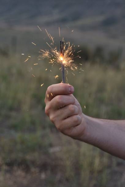 istock Cropped Hand Holding Illuminated Sparkler 1081499624