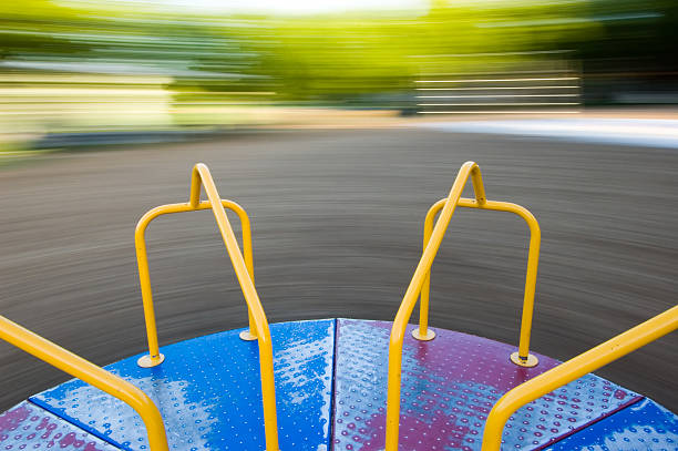 merry-go-round spinning, motion blur auf hintergrund - spielplatzkarussell stock-fotos und bilder