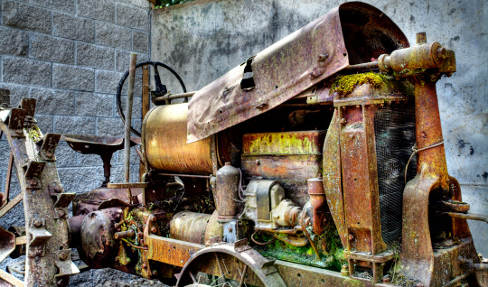 A rusty vintage Soviet truck stands abandoned by industrial buildings.