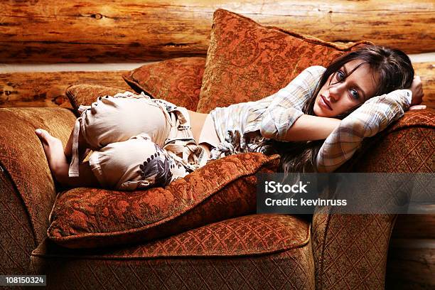 Foto de Jovem Mulher Deitada Na Grande Cadeira e mais fotos de stock de Aconchegante - Aconchegante, Adulto, Almofada