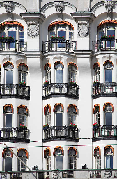 Ornate art nouveau building facade with intricate details against a backdrop of blue sky and clouds