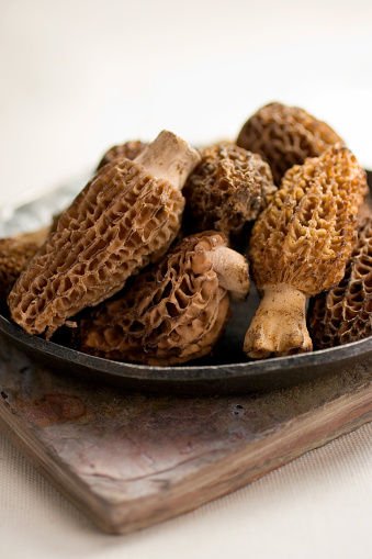 large morel mushrooms on a wooden table.