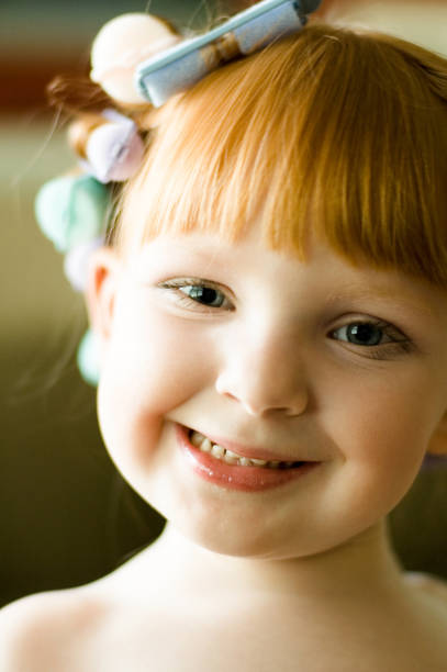 Portrait of Little Girl with Red Hair in Curlers stock photo