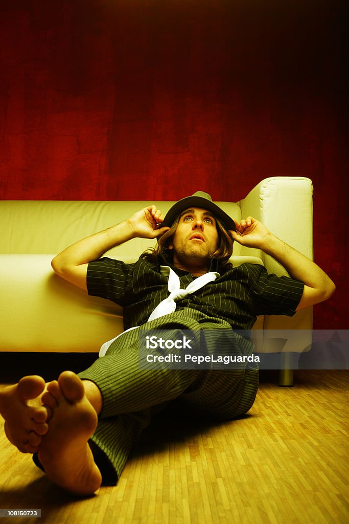 Młody człowiek relaksujący na kanapie i Pochylać się - Zbiór zdjęć royalty-free (25-29 lat)