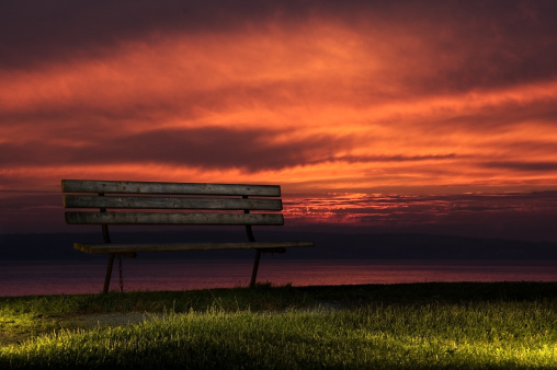 White wooden bench on the beach on the sea and background