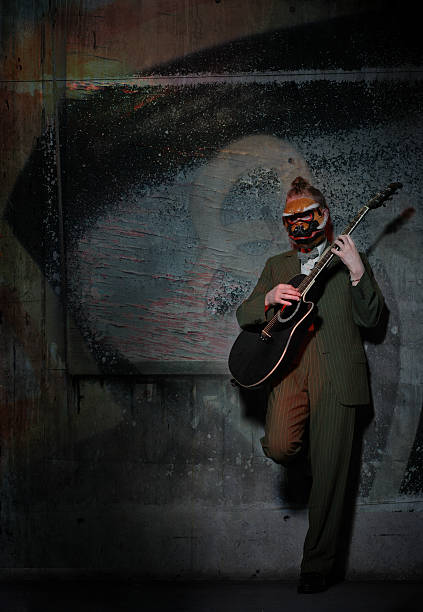 istock Musician Wearing Suit and Playing Guitar Against Wall 108150868