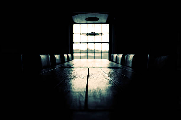 Low key empty boardroom scene; black and white stock photo