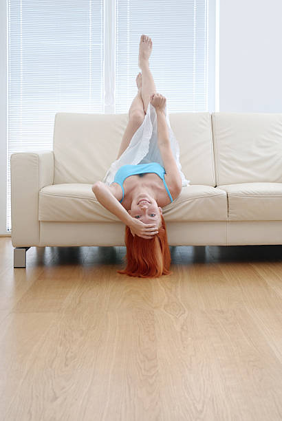 istock Young Woman Lying Upside Down on Couch 108150938