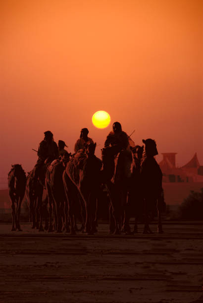 istock Caravan of People Travelling on Camels at Sunset 108150947