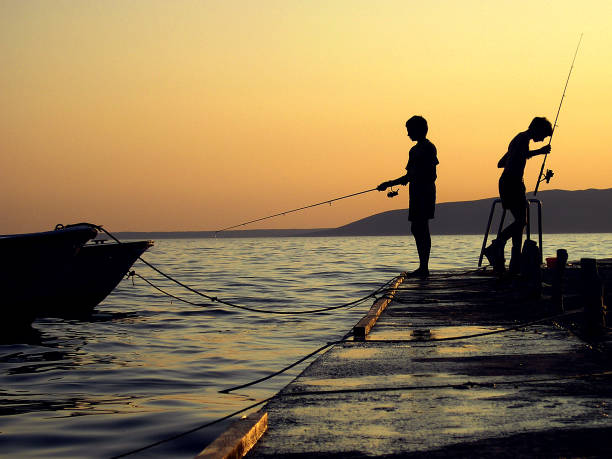 Men Fishing in the Sea from the Pier at Sunset · Free Stock Photo