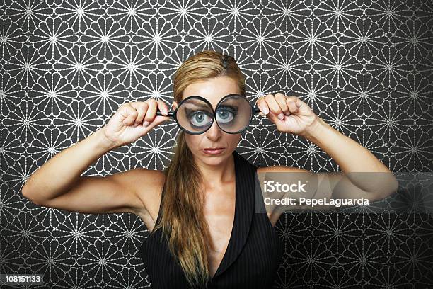 Young Woman Holding Magnifying Glasses To Both Eyes Stock Photo - Download Image Now