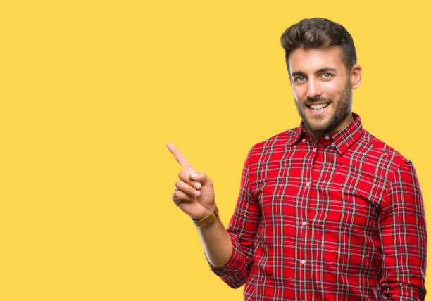 istock Young handsome man over isolated background with a big smile on face, pointing with hand and finger to the side looking at the camera. 1081513798