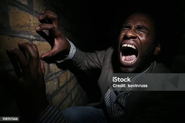 Man Yelling While Clawing A Brick Wall Stock Photo - Download Image Now - Claustrophobia, African-American Ethnicity, Fear