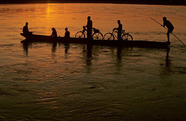 Children riding bicycles and running In the early light of the day as the sun shines a beautiful orange glow.