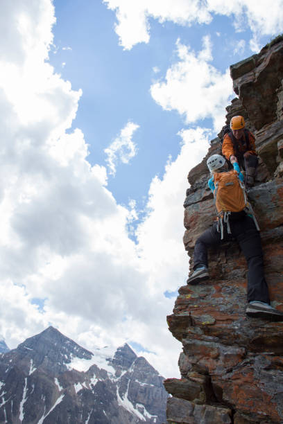istock Climber gives a helping hand to other climber 1081516636