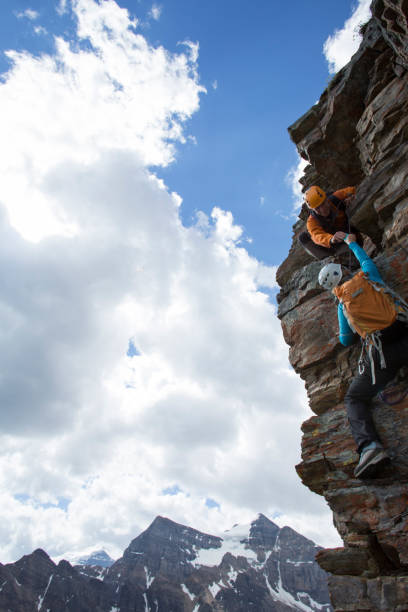 istock Climber gives a helping hand to other climber 1081516774
