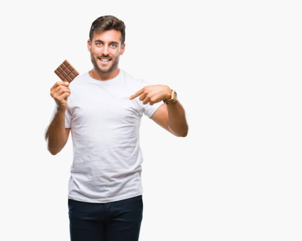 istock Young handsome man eating chocolate bar over isolated background with surprise face pointing finger to himself 1081517200