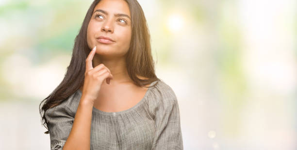 istock Young beautiful arab woman over isolated background with hand on chin thinking about question, pensive expression. Smiling with thoughtful face. Doubt concept. 1081518778