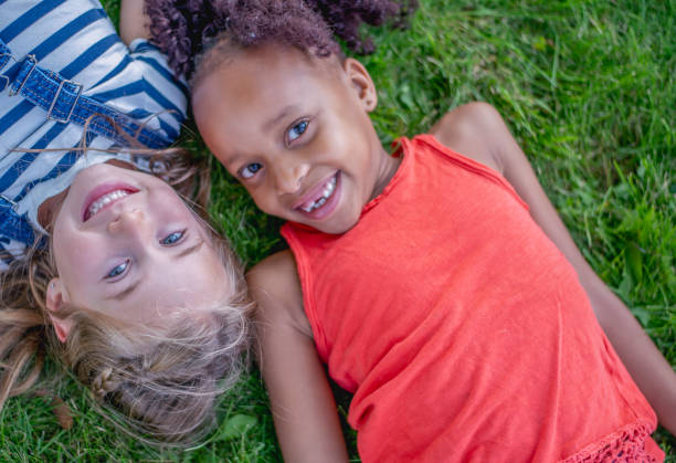 istock Two girls lying on the grass in a park 1081521580