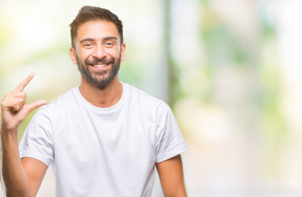 istock Adult hispanic man over isolated background smiling and confident gesturing with hand doing size sign with fingers while looking and the camera. Measure concept. 1081522466