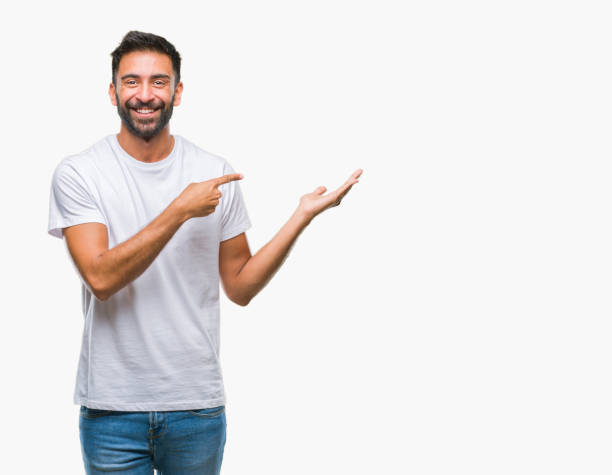 istock Adult hispanic man over isolated background amazed and smiling to the camera while presenting with hand and pointing with finger. 1081522488