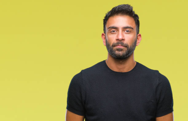 istock Adult hispanic man over isolated background with serious expression on face. Simple and natural looking at the camera. 1081524842