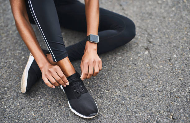 Got to get them tight Closeup shot of a sporty woman tying her shoelaces while exercising outdoors abstract adult body body part stock pictures, royalty-free photos & images