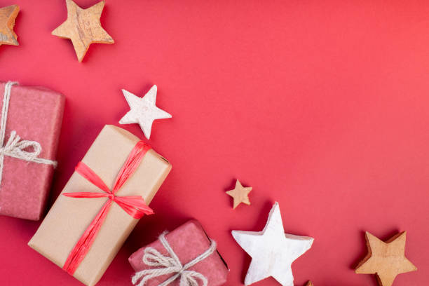 istock Christmas composition, greeting card. Christmas red decorations, stars and gift boxes on red background. Flat lay, top view, space for the text 1081533254