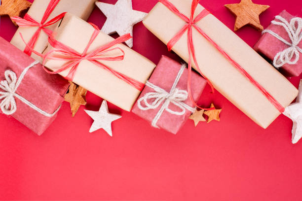 istock Christmas composition, greeting card. Christmas red decorations, stars and gift boxes on red background. Flat lay, top view, space for the text 1081533260