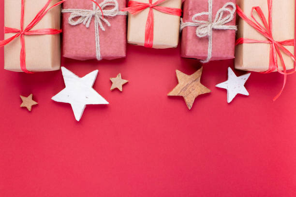 istock Christmas composition, greeting card. Christmas red decorations, stars and gift boxes on red background. Flat lay, top view, space for the text 1081533262