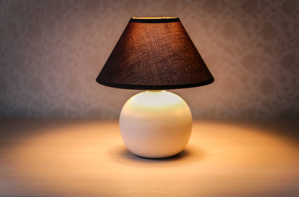 istock Table lamp with brown shade on a wooden table 1081545738