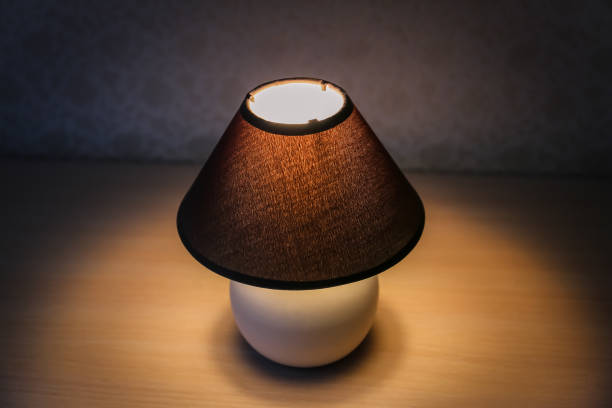 istock Table lamp with brown shade on a wooden table 1081545788