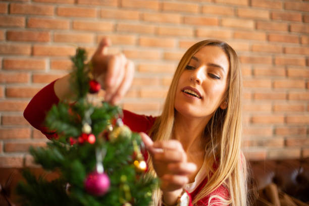 istock Smiling Blonde Woman Decorating Christmas Tree 1081551374