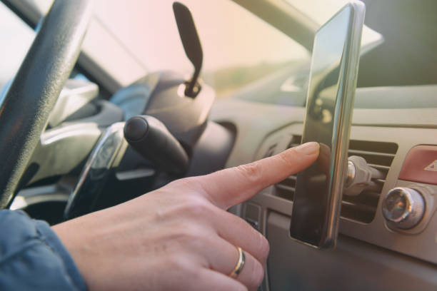 женщина, используя smort телефон во время вождения автомобиля - driving mobile phone car talking стоковые фото и изображения